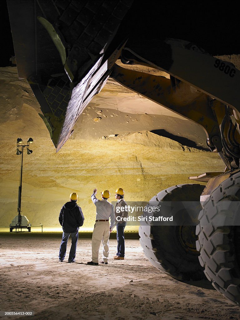 Construction workers on floor of sand mine at night