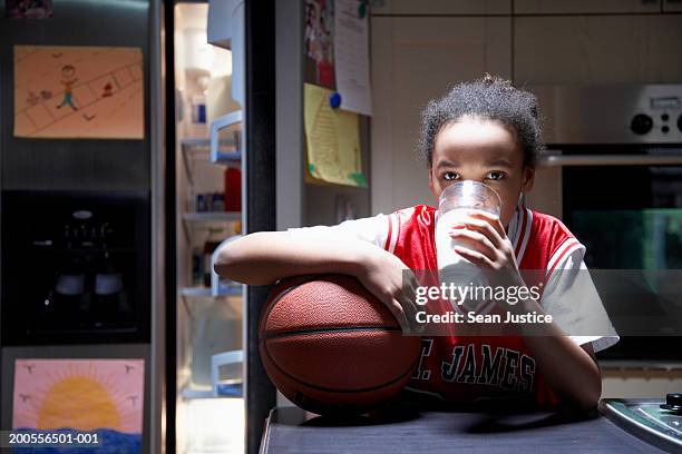 girl (10-12) drinking milk by basketball, portrait - calcio sport imagens e fotografias de stock