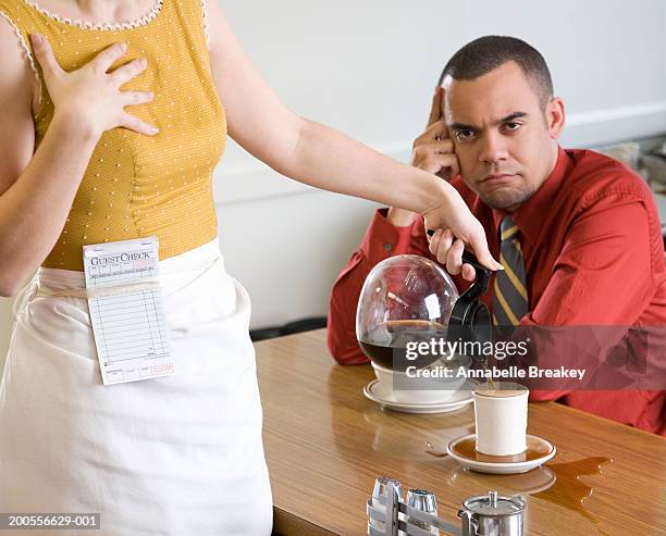 waitress pouring coffee for man, spilling over table - overworked waitress stock pictures, royalty-free photos & images