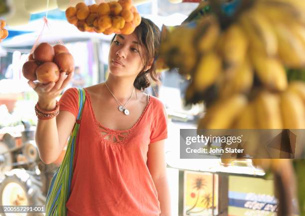young woman choosing fruit in market# - fruta tropical fotografías e imágenes de stock