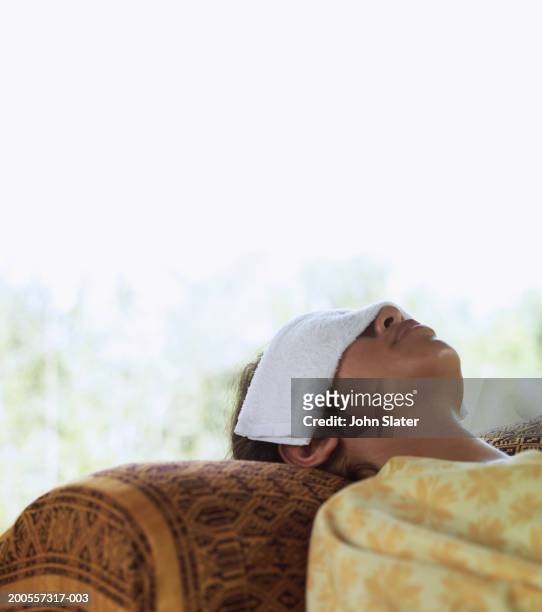 young woman resting with towel over eyes - mani sugli occhi foto e immagini stock