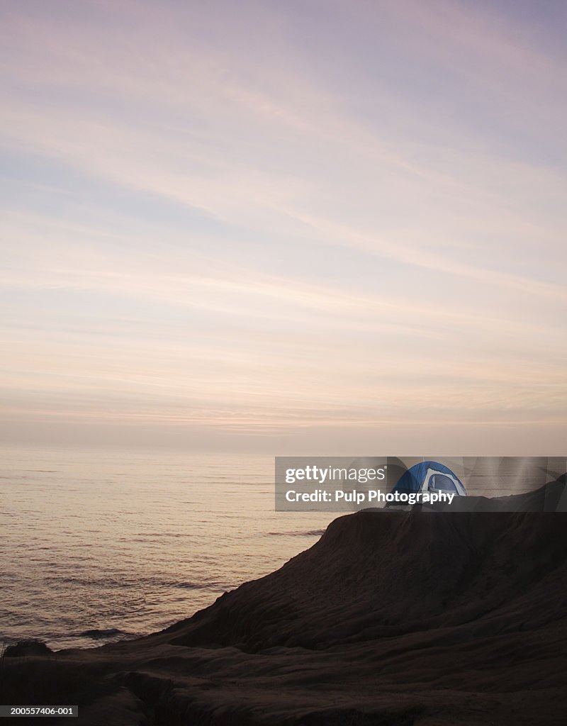 Tent on coastline at dusk