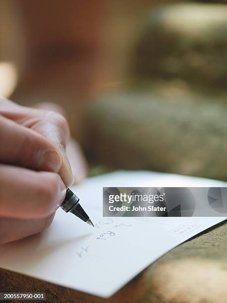young man writing postcard on step, close-up - postkarte stock-fotos und bilder