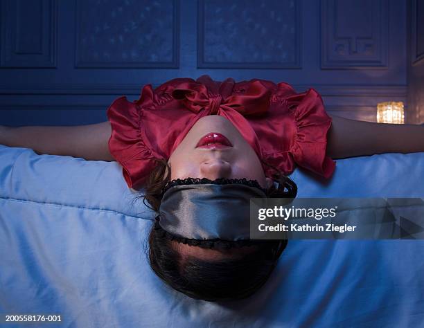 young woman lying on bed with blindfold - blindfold stock pictures, royalty-free photos & images