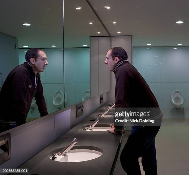 man looking in bathroom mirror - man mirror stock pictures, royalty-free photos & images