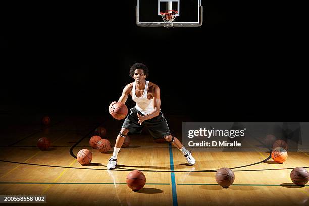 basketball player dribbling ball on court - dribbling sport fotografías e imágenes de stock