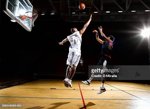 basketball player shooting fade away while opponent blocks shot - basket ball fotografías e imágenes de stock