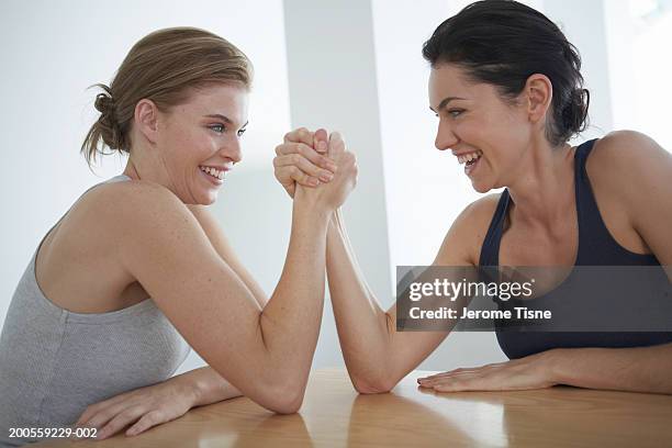 two young women arm wrestling, waist up - arm wrestle stock pictures, royalty-free photos & images
