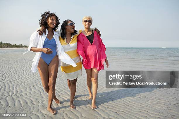 women walking at shoreline - black women in swimsuits stock pictures, royalty-free photos & images