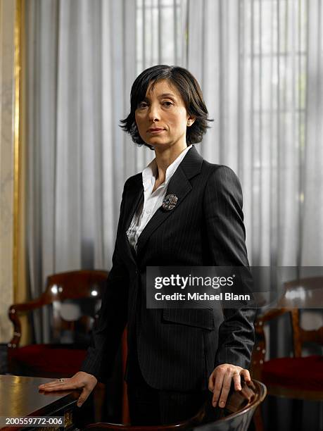 mature woman standing by conference table, portrait - politician stock-fotos und bilder