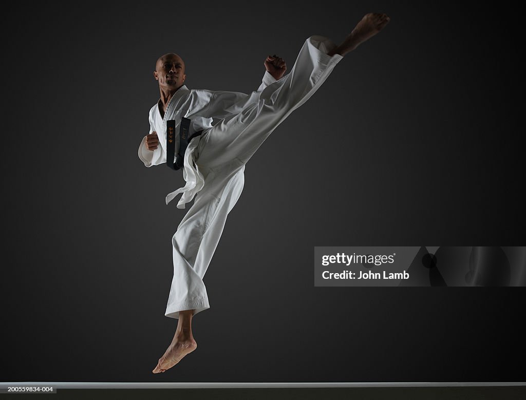 Man in mid-air performing karate kick