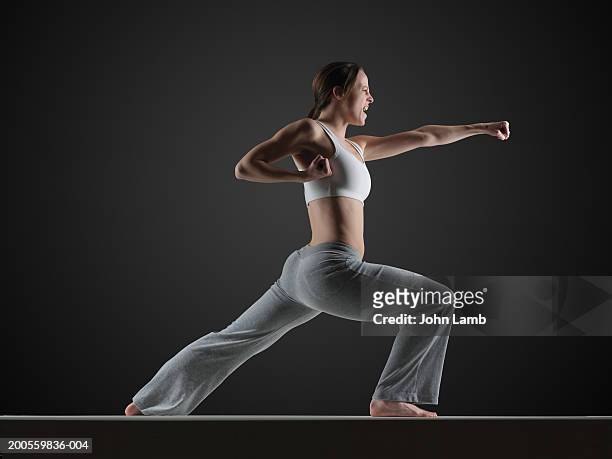 young woman practising karate, side view - karate woman stock pictures, royalty-free photos & images