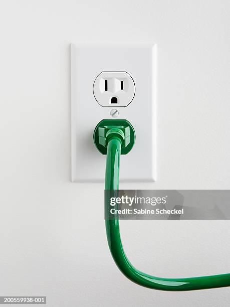 plug socket with green power cable on wall, close-up - power point foto e immagini stock