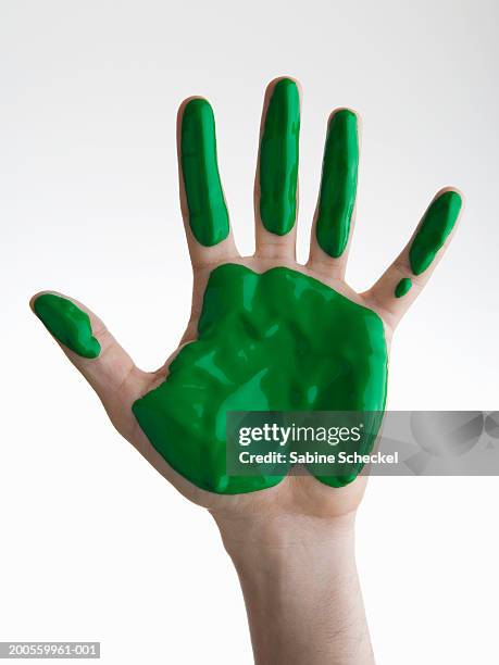 human hand with green paint against white background, close-up - manos pintadas fotografías e imágenes de stock