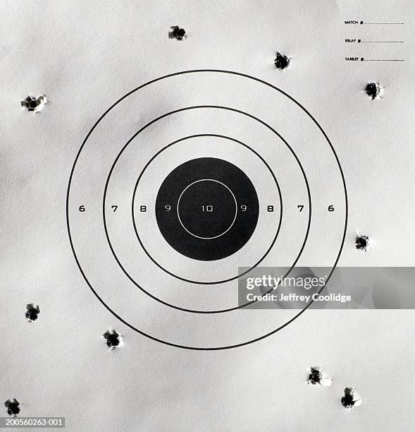 bullet holes around bull's-eye of shooting target - bullet hole stock pictures, royalty-free photos & images