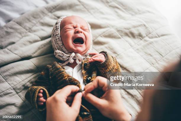 new born baby crying during changing cloth. - innocence stock pictures, royalty-free photos & images