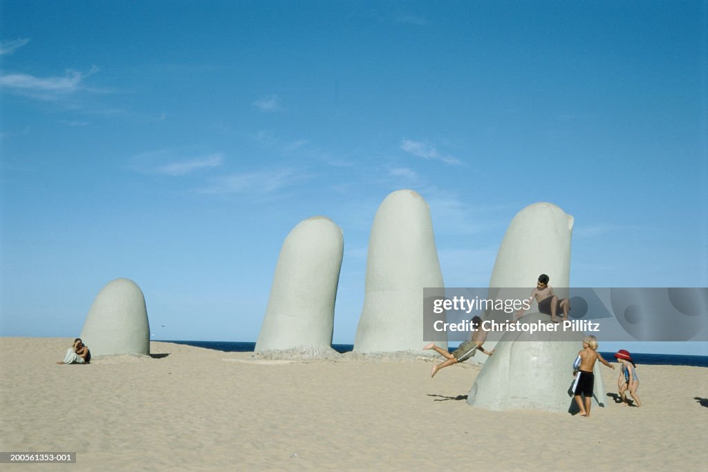 Uruguay, Punta del Este, children playing on sculpture on Brava beach