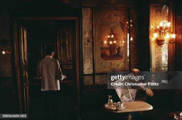 Italy, Venice, interior of Cafe Florian, senior man reading newspaper.