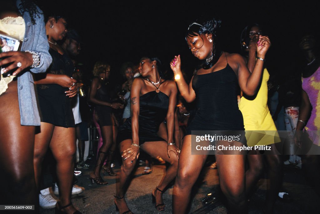 Jamaica, Kingston, group of women dancing in street, night