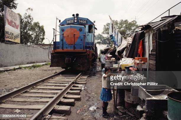 Mexico, Mexico City, child in slum next to railway line.