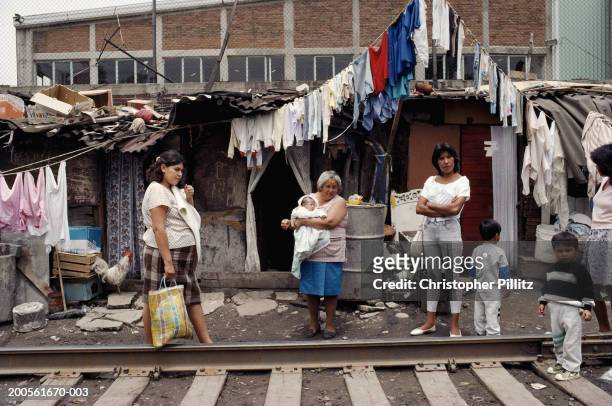 Mexico, Mexico City, women and children in slum next to train tracks.