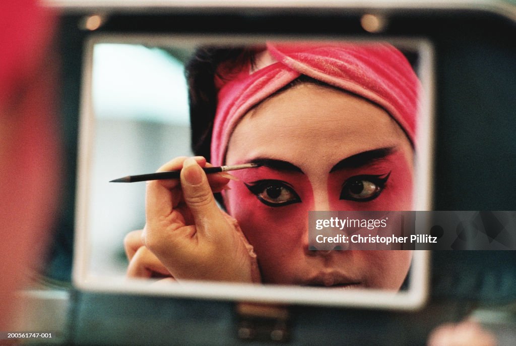 Taiwan,Chinese opera performer putting on make-up,reflection in mirror