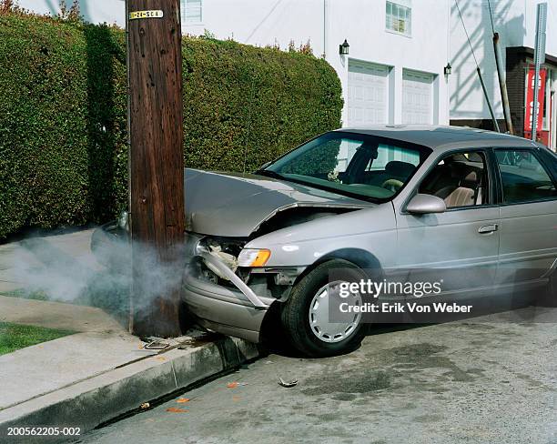 car crash against telephone pole by road - unfall stock-fotos und bilder