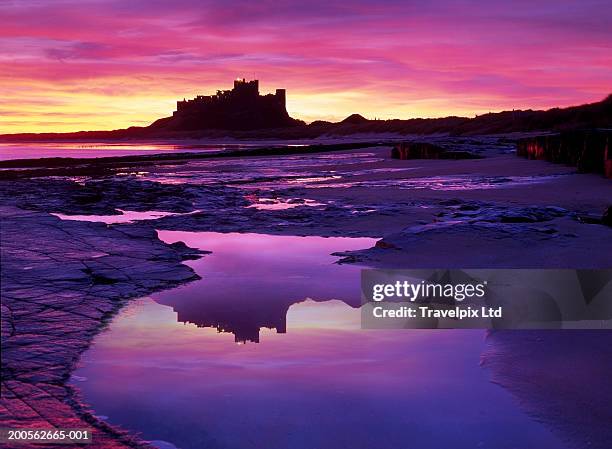 england, northumberland, bamburgh castle, view across beach, sunset - bamburgh castle stock pictures, royalty-free photos & images