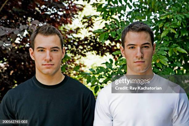 young male twins in black and white t-shirts outdoors, portrait - same people different clothes - fotografias e filmes do acervo