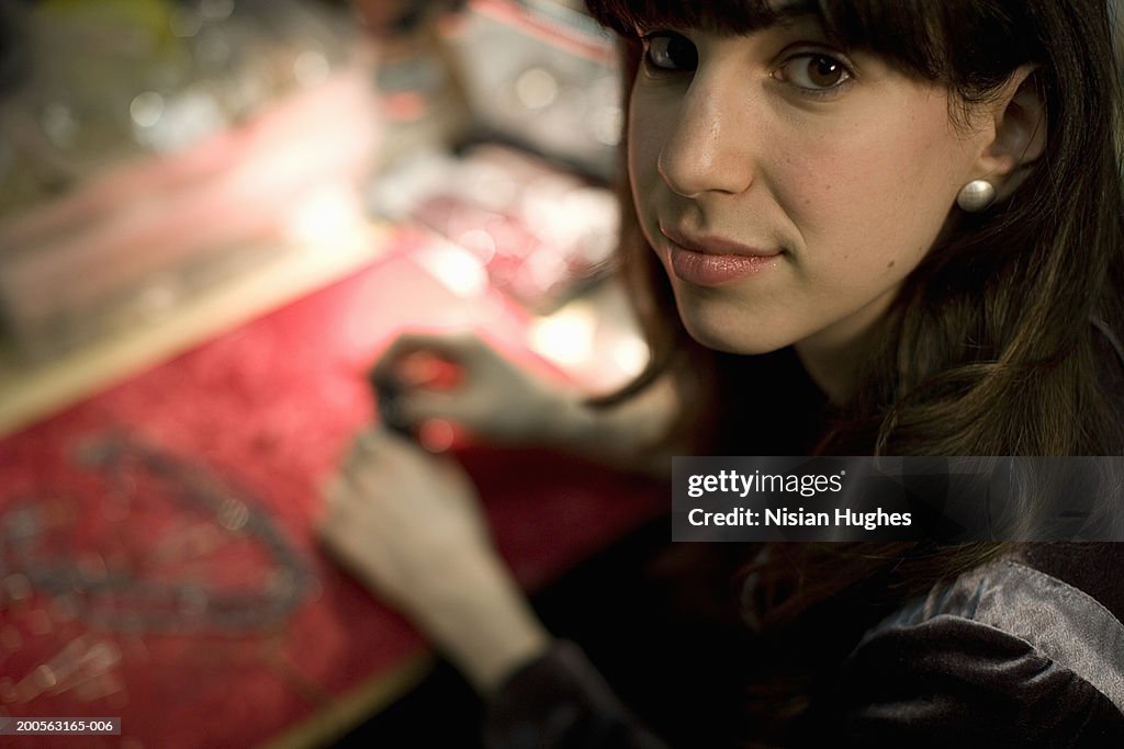 Female jeweller in workshop, close-up, portrait