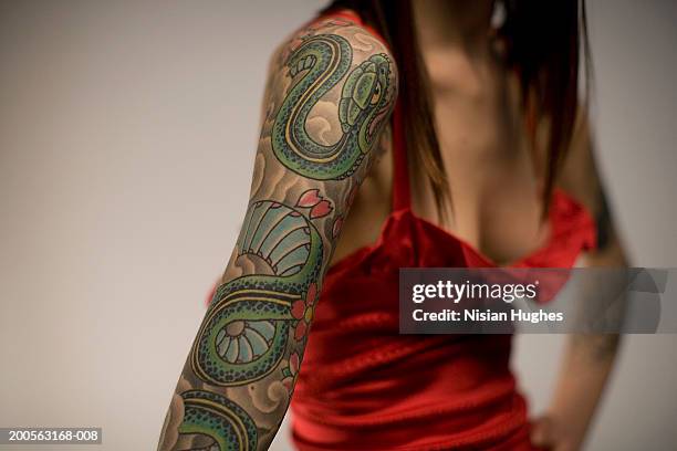 woman with tattooed arm, mid section - tattoo closeup stock pictures, royalty-free photos & images