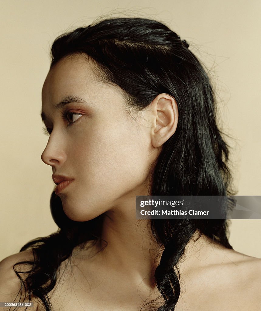 Young woman of hispanic descent, looking to side, close-up