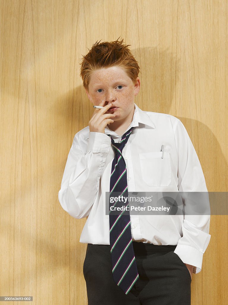 Boy (10-11) wearing shirt and tie, smoking cigarette, portrait