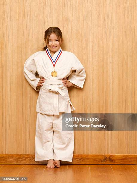 girl (6-7) with medal in judo kit, portrait - judo stockfoto's en -beelden