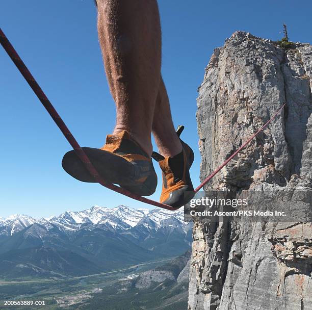 person walking on tightrope, low section - hochseil stock-fotos und bilder