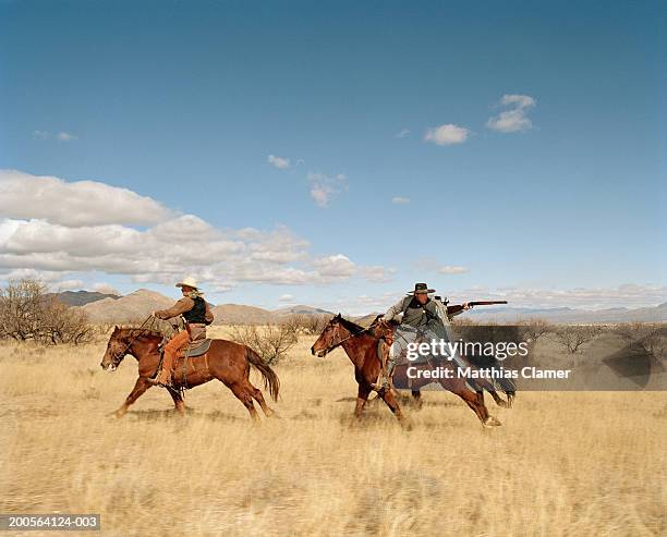 cowboys riding on horse, close-up - cowboy gun foto e immagini stock