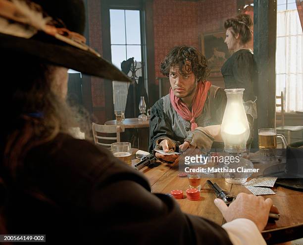 two men playing cards at bar - saloon photos et images de collection