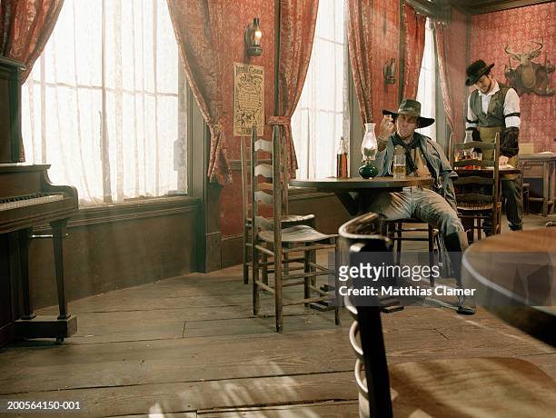 cowboy at saloon with bartender at background - saloon photos et images de collection