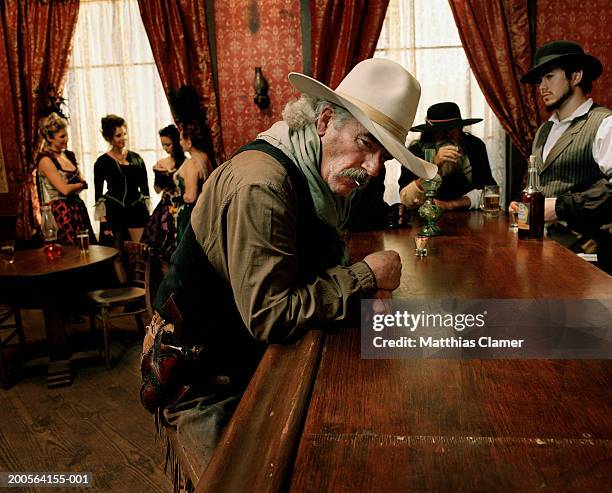 cowboy at bar counter in saloon - cowboy costume stock-fotos und bilder