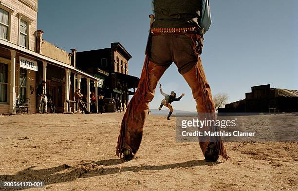 cowboys having gun duel in old west town - cowboy stock-fotos und bilder