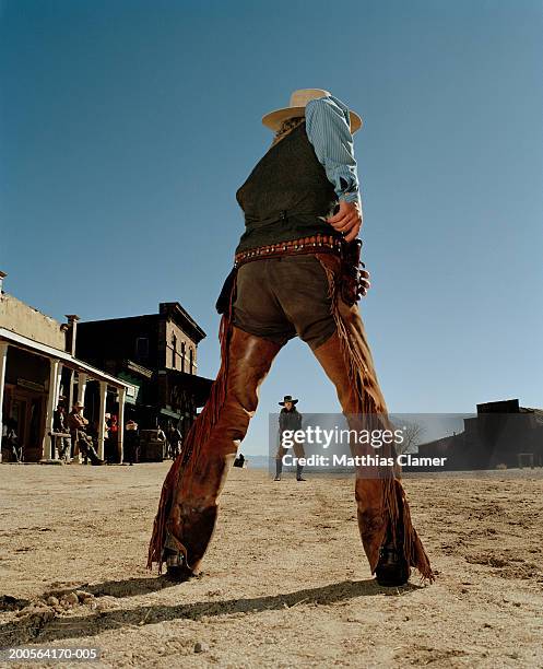 cowboys having gun duel in old west town - cowboy gun duel fotografías e imágenes de stock