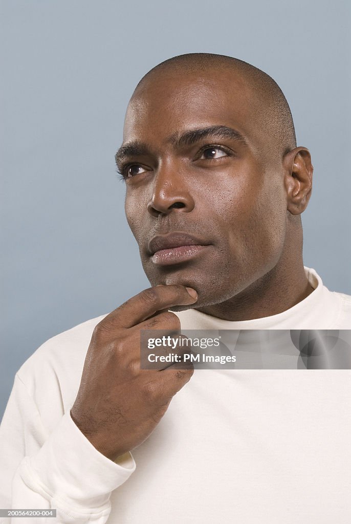 Man with hand on chin, looking away, close-up