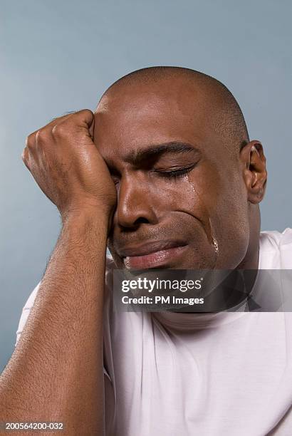 man with head in hands, crying, close-up - teardrop stockfoto's en -beelden