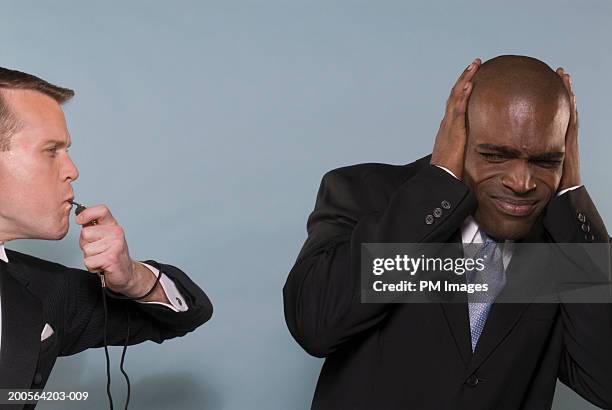 man blowing whistle near businessman - whistle blowing stock pictures, royalty-free photos & images