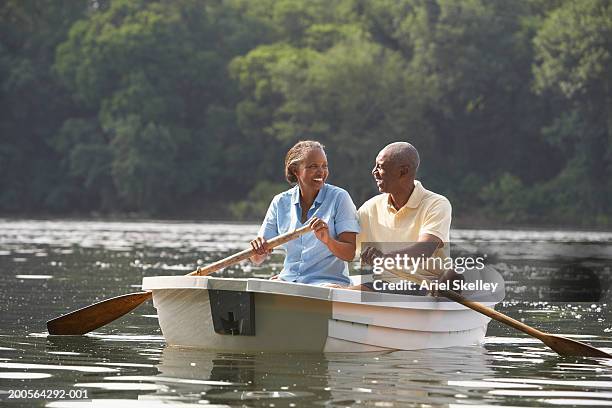 couple canoeing on river, smiling - seniors canoeing stock pictures, royalty-free photos & images
