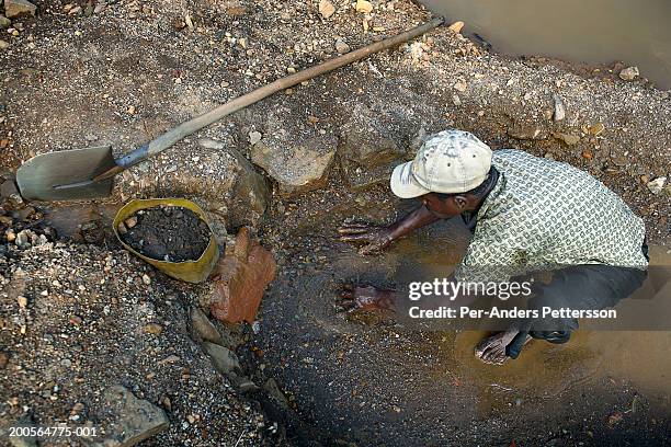 africa, goma, congo, young man squatting, digging with hands - mining hats stock pictures, royalty-free photos & images