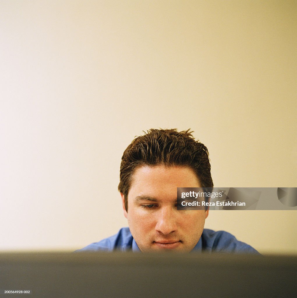 Office worker working on desktop pc, view over computer