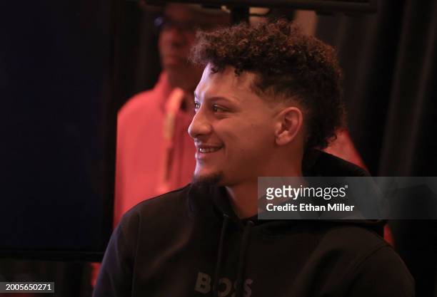 Quarterback Patrick Mahomes of the Kansas City Chiefs smiles as he watches his head coach Andy Reid take questions during a news conference for the...