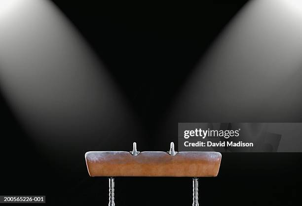 gymnastics pommel horse illuminated by two spotlights, side view - gymnastics equipment stock pictures, royalty-free photos & images