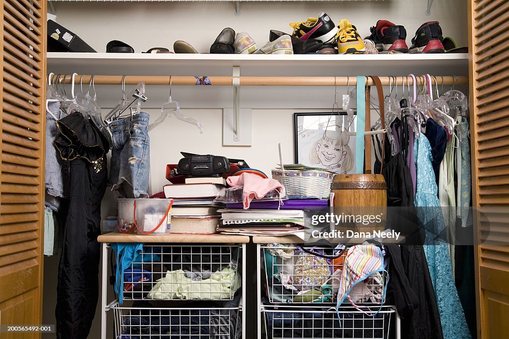 Shoes and clothes in closet, close-up